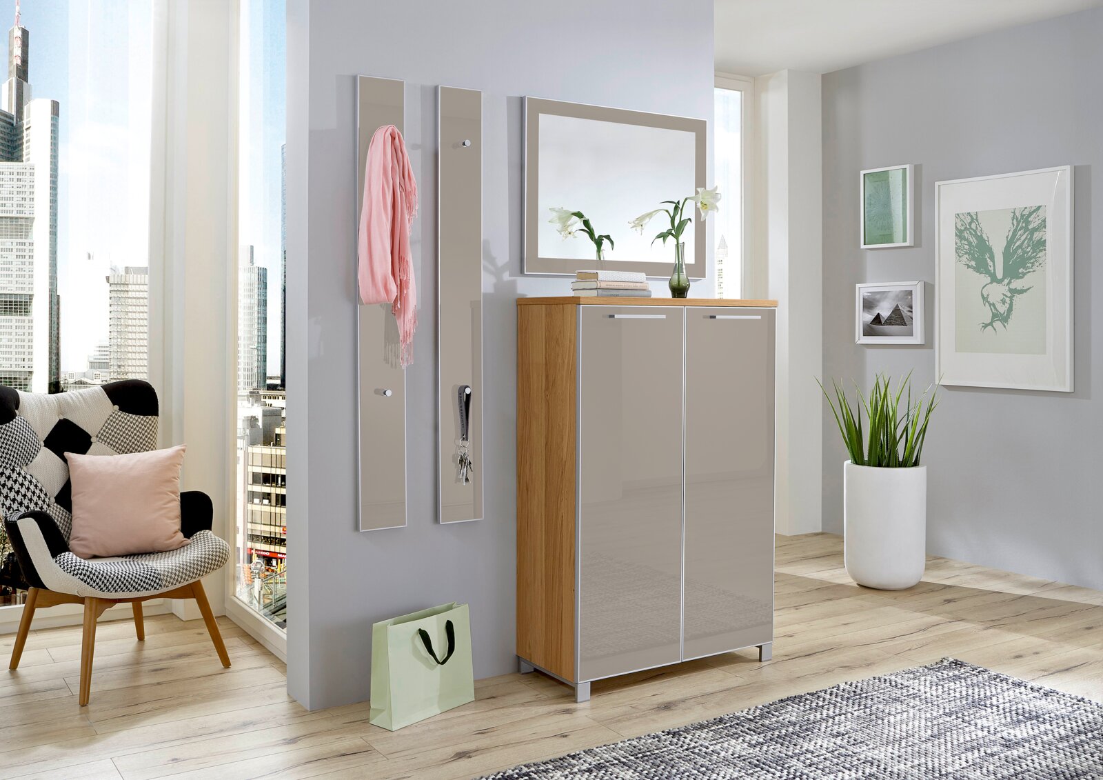 Modernes Garderoben-Set mit Spiegel, Schrank und Hakenleisten in einem hellen Raum mit Stadtblick, aus der Perspektive von vorne betrachtet.