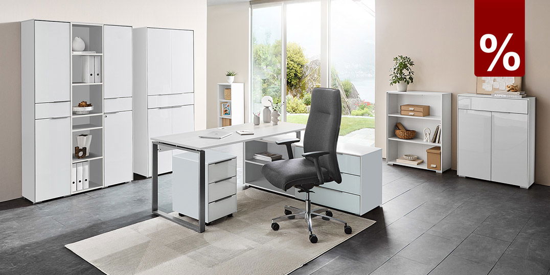 Modernes, helles Büro mit großem Schreibtisch, ergonomischem Stuhl, weißen Schränken und Blick ins Grüne