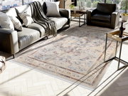 Orientteppich in einem modernen Wohnzimmer, von oben betrachtet, mit einem Sofa und einem Sessel im Hintergrund.