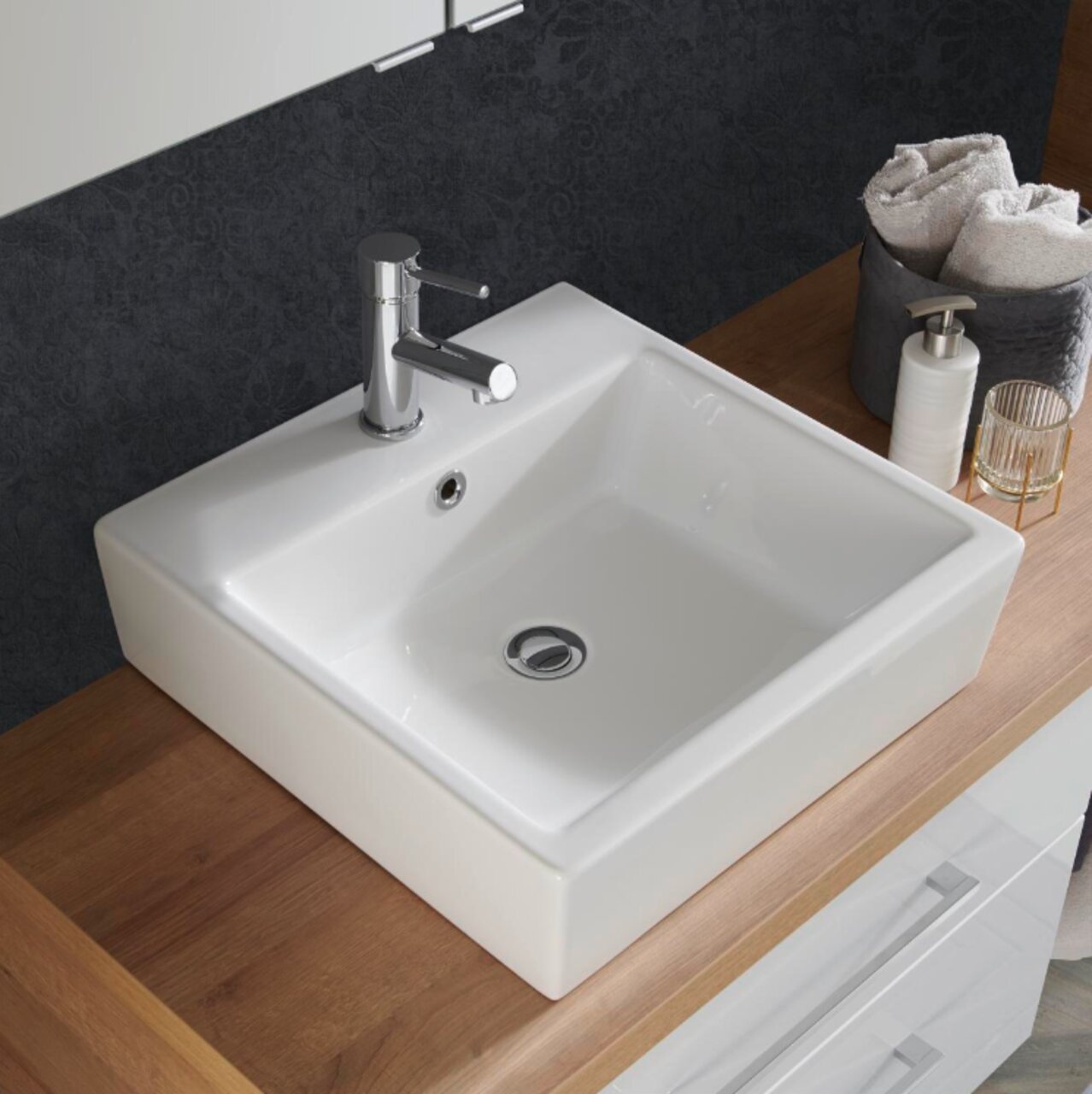 Moderner rechteckiger Waschbecken mit Chromarmatur, von oben betrachtet, auf einer Holzoberfläche montiert.