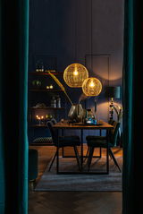 Zwei hängende Lampen in Kugelform aus goldenem Drahtgeflecht, beleuchtet in einem stilvoll eingerichteten Esszimmer mit dunklen Wänden und einem Holztisch, seitliche Perspektive.
