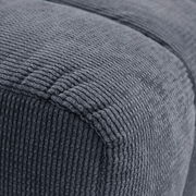 Nahaufnahme eines grauen, strukturierten Hockers aus Stoff, seitliche Perspektive