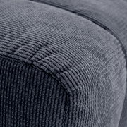 Nahaufnahme eines grauen, strukturierten Hockers aus Stoff, seitliche Perspektive