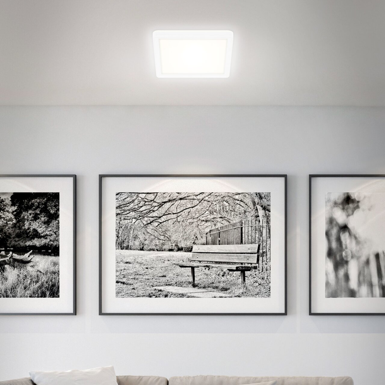 Quadratische LED-Deckenleuchte in einem modernen Wohnzimmer, von unten betrachtet.