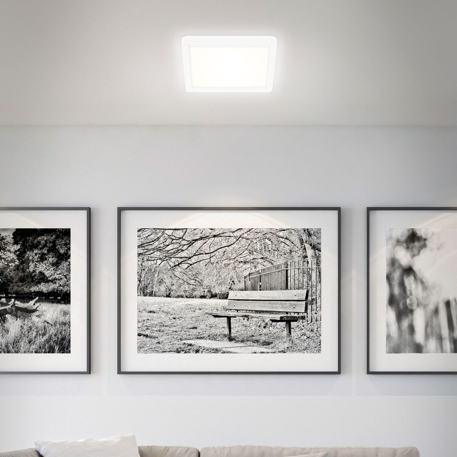 Quadratische LED-Deckenleuchte in einem modernen Wohnzimmer, von unten betrachtet.