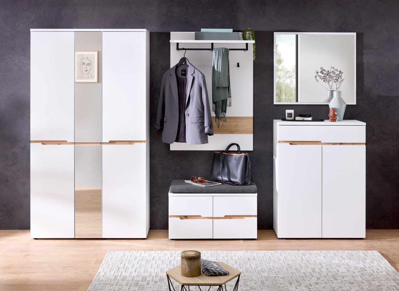 XORA XL-garderobekast MEMPHIS Moderne garderobecombinatie in wit met houten details, bestaande uit een grote kast, een garderobepaneel met haken en een legplank, een bankje met opbergruimte en een spiegel. Vooraanzicht.
