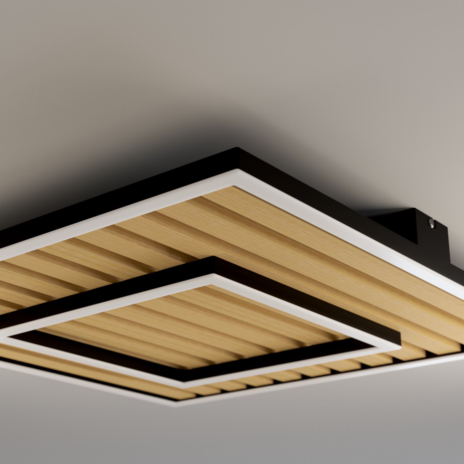 Moderne quadratische Deckenleuchte mit schwarzem Rahmen, weißen Lichtflächen und Holzlamellen, aus Untersicht schräg von unten fotografiert