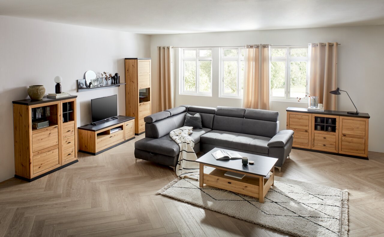 Wohnzimmer mit modernen Holzmöbeln, bestehend aus Highboard, TV-Lowboard, Vitrine und Sideboard, in einer hellen und gemütlichen Atmosphäre, seitliche Perspektive.