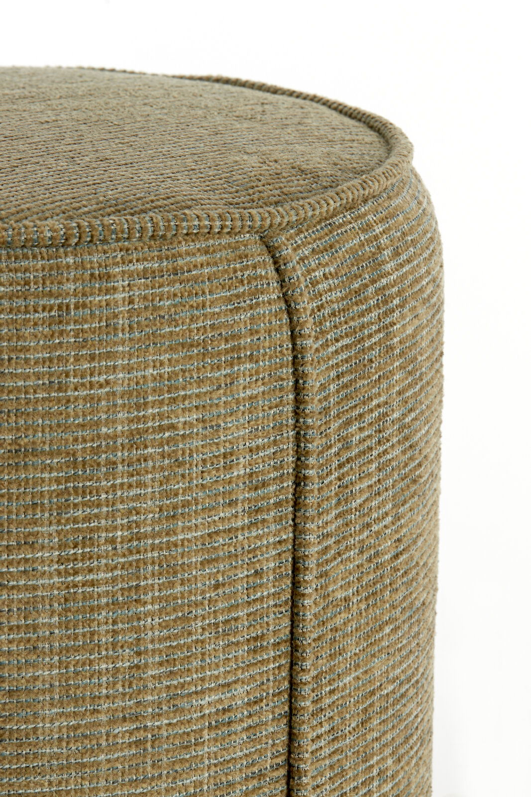 Nahaufnahme eines Sitzpuffs mit texturierter, beige-grüner Oberfläche, seitliche Perspektive