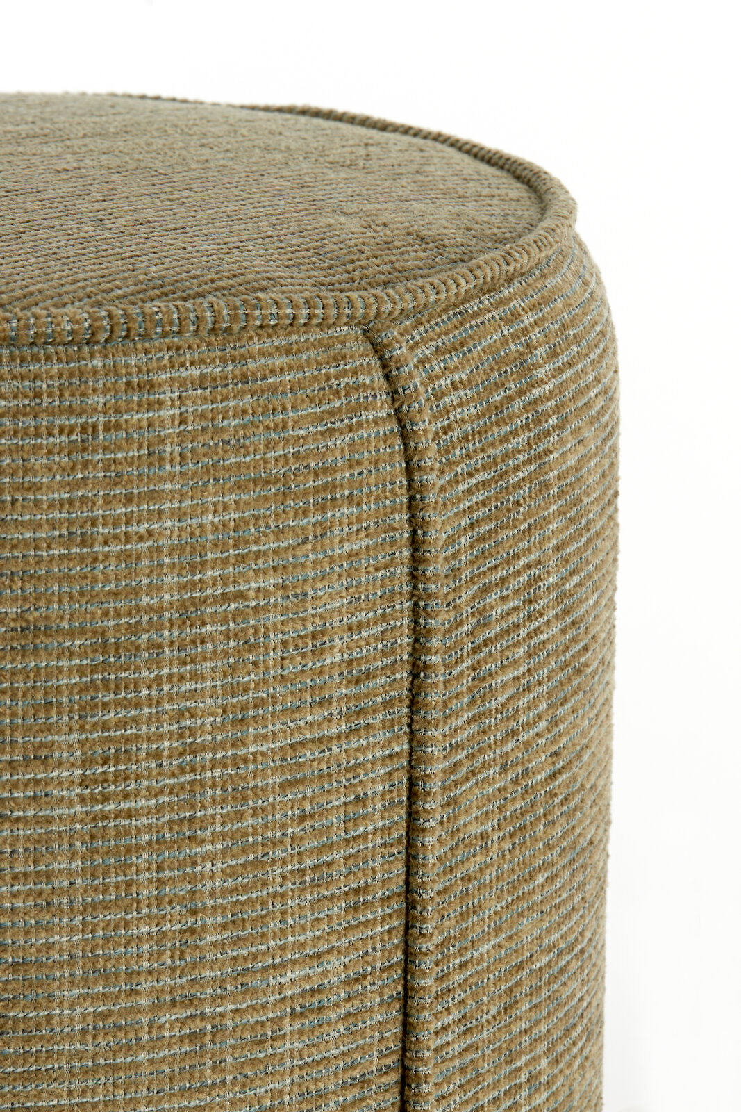 Nahaufnahme eines Sitzpuffs mit texturierter, beige-grüner Oberfläche, seitliche Perspektive