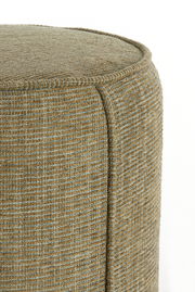 Nahaufnahme eines Sitzpuffs mit texturierter, beige-grüner Oberfläche, seitliche Perspektive