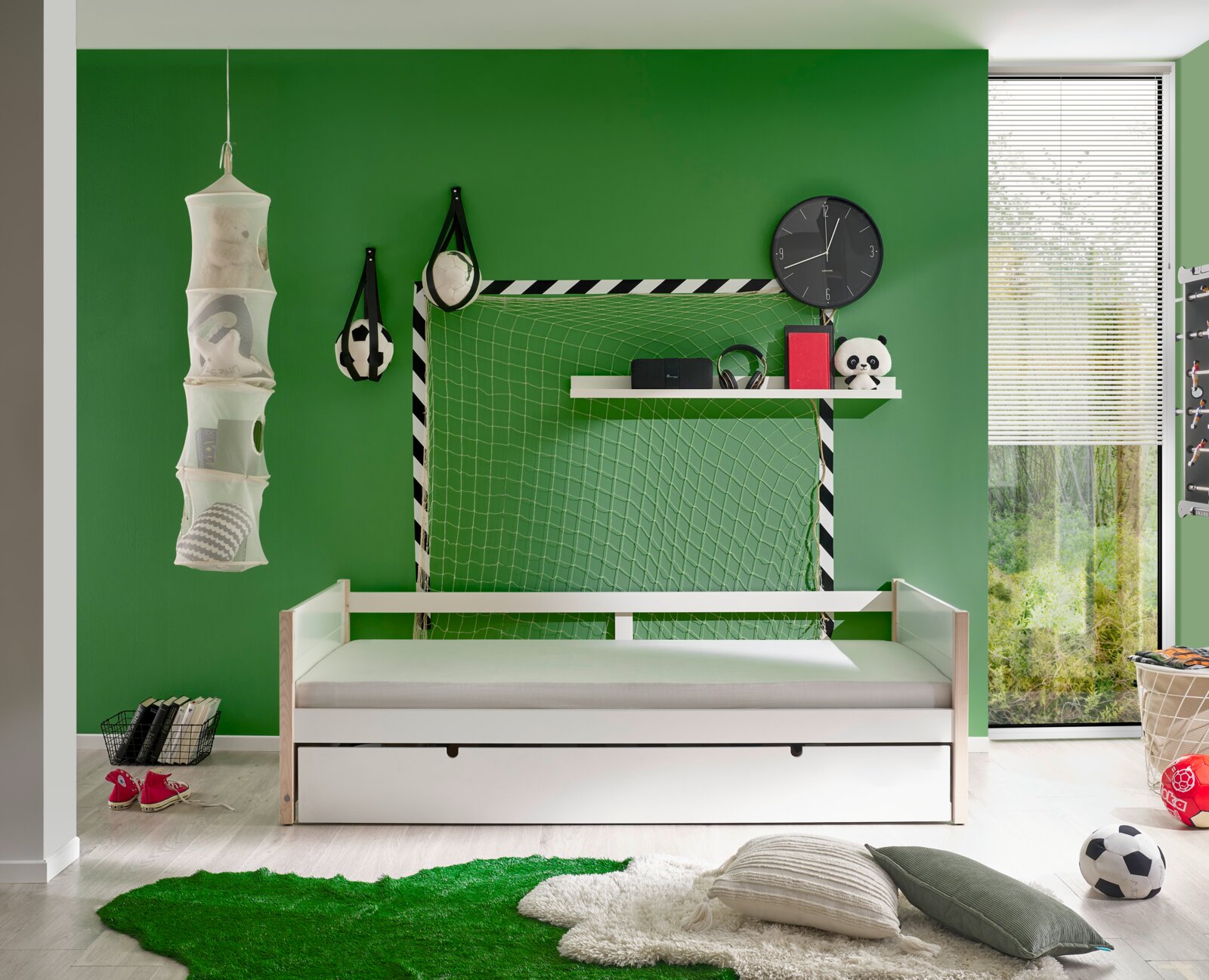 Jeugdbed in een kinderkamer met een groen voetbalthema, zijaanzicht