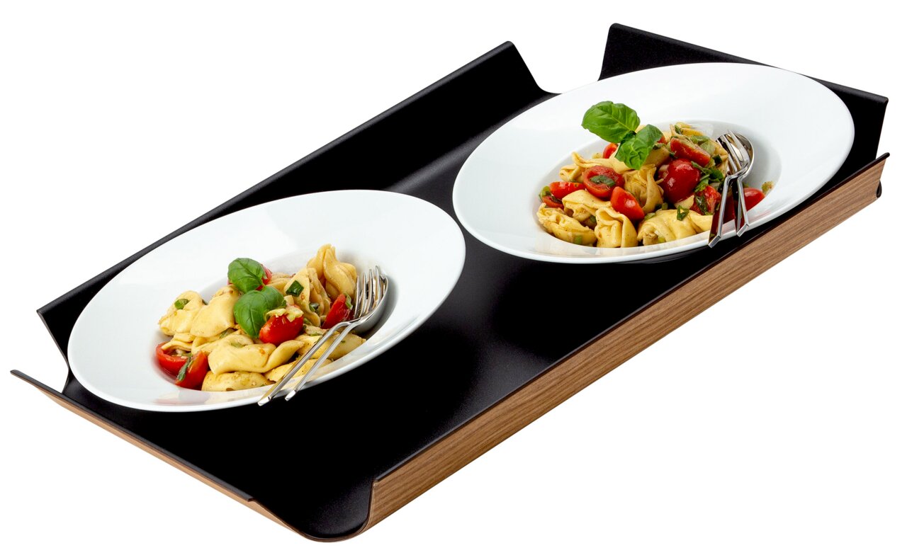 Zwart, antislip dienblad met twee witte borden, gevuld met pasta en tomaten, gezien vanuit een zijaanzicht.