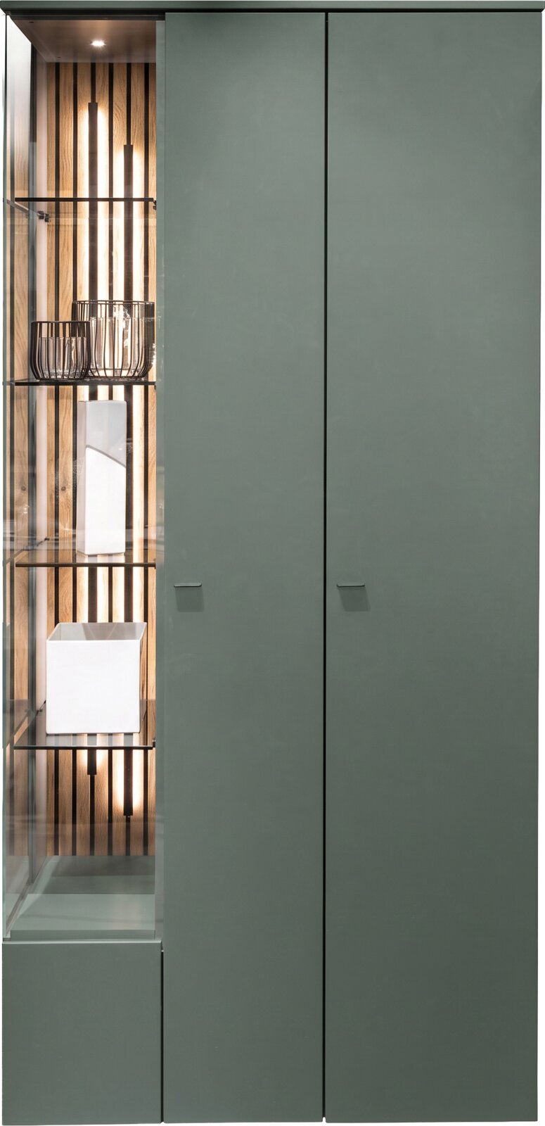 Vooraanzicht van een hoge, moderne vitrinekast in donkergroen met twee gesloten deuren en een verlicht glazen zijvak met decoratieve accessoires