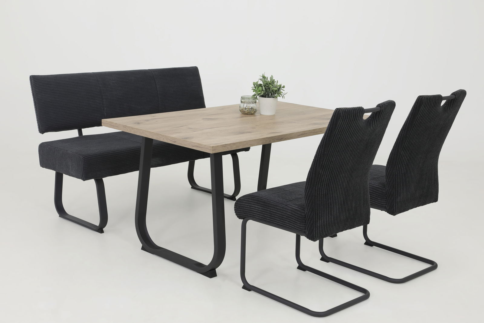 Essgruppe mit einem rechteckigen Holztisch und schwarzen Schwingstühlen, seitliche Perspektive