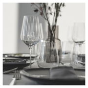 Elegantes Rotweinset mit Sternschliff, bestehend aus verschiedenen Gläsern auf einem gedeckten Tisch, seitliche Perspektive.