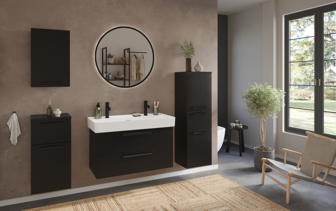 Moderner schwarzer Unterschrank in einem stilvollen Badezimmer, frontal betrachtet, mit einem großen runden Spiegel darüber.