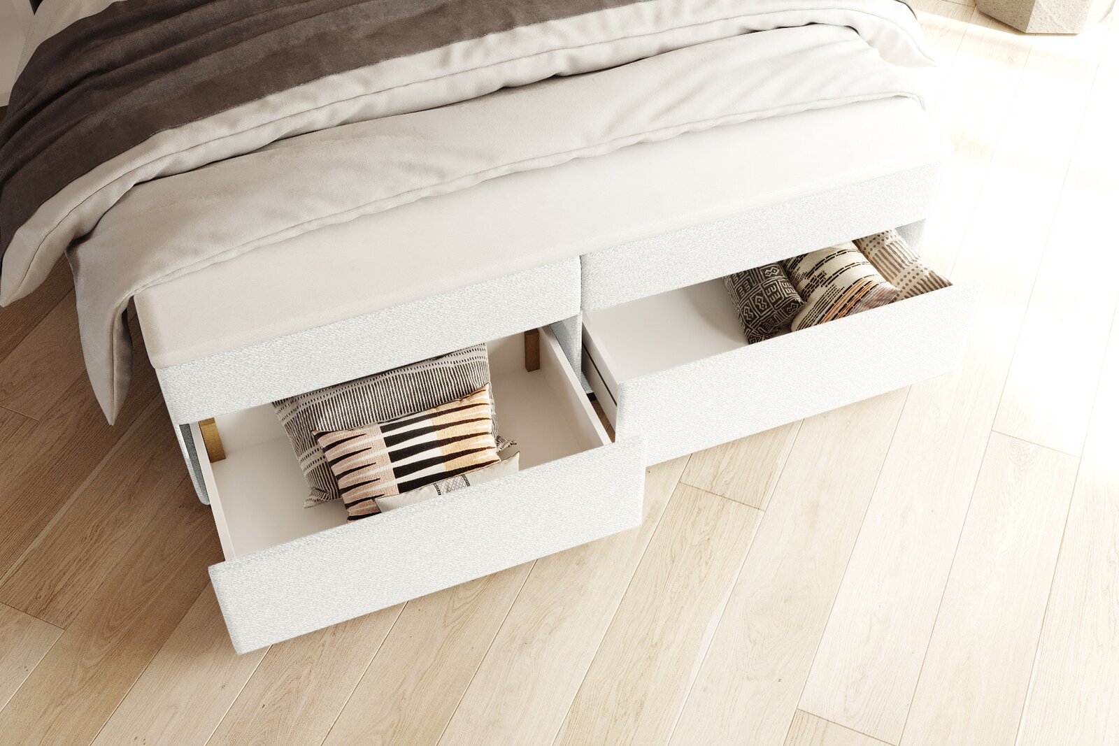 Wit gestoffeerd bed met twee uittrekbare lades voor opbergruimte, voorzien van kussens en dekens, gefotografeerd vanuit een licht verhoogd, schuin perspectief van voren