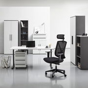 Moderne Büromöbel in einem hellen Raum, darunter ein Winkelschreibtisch, Rollcontainer, Aktenschränke und ein ergonomischer Bürostuhl. Frontalansicht.