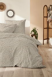 Bettwäsche-Set mit dezentem Leopardenmuster in einem gemütlichen Schlafzimmer, seitliche Perspektive