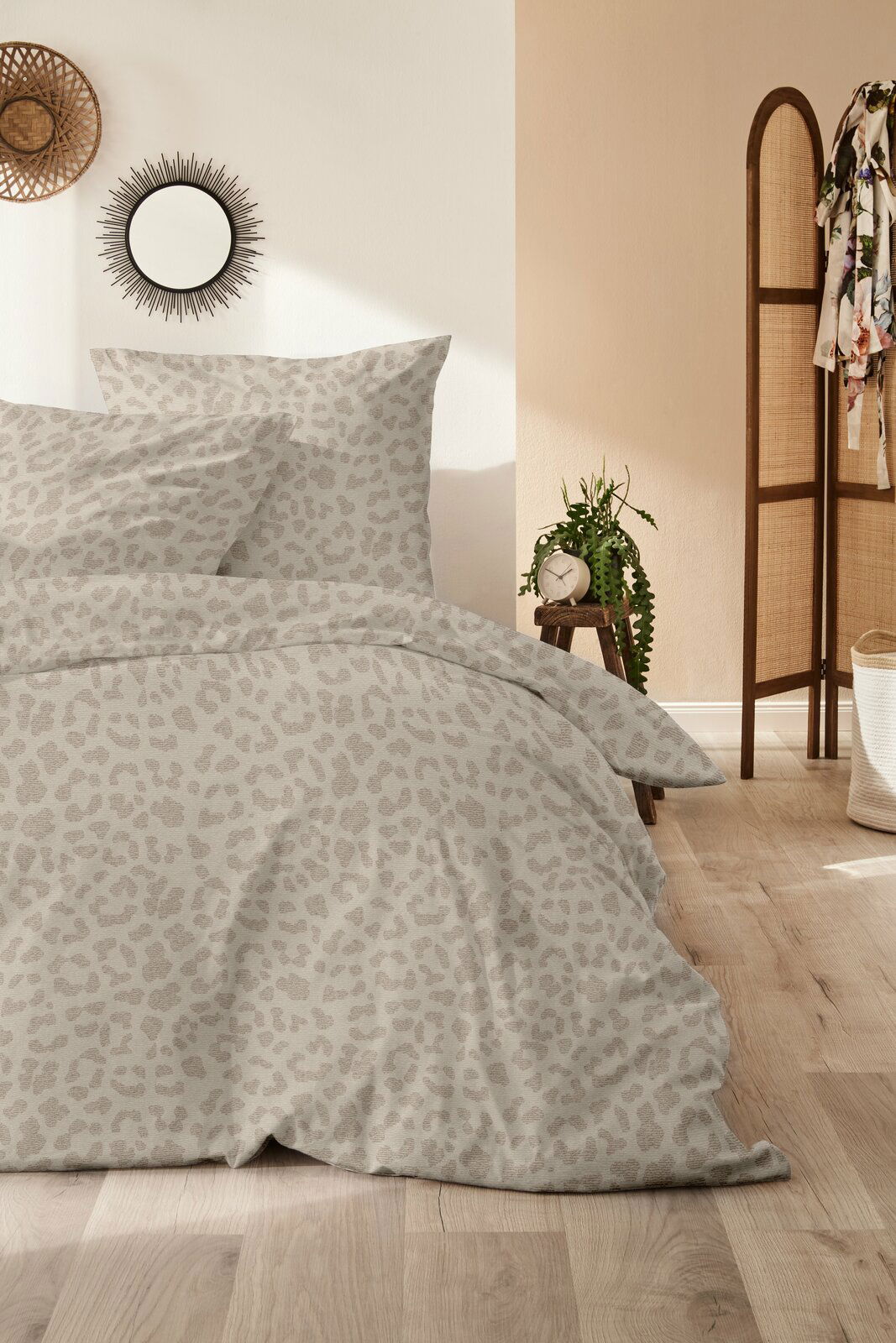 Bettwäsche-Set mit dezentem Leopardenmuster in einem gemütlichen Schlafzimmer, seitliche Perspektive
