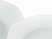 Nahaufnahme eines weißen, glänzenden Kunststoffstuhls mit geschwungener Rückenlehne und Sitzfläche, Ansicht schräg von oben