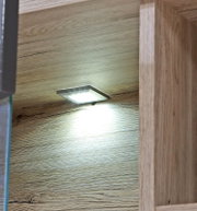 Verlichting onderin een houten boekenkast, zijaanzicht