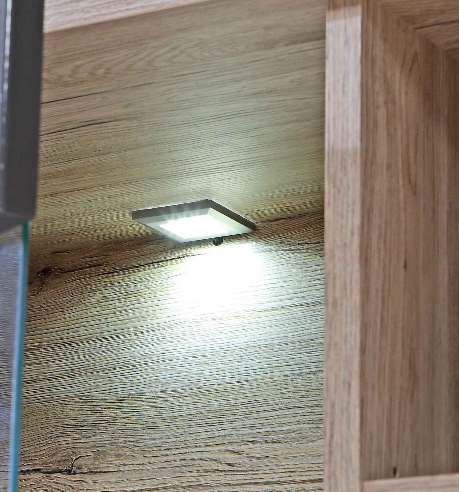 Verlichting onderin een houten boekenkast, zijaanzicht