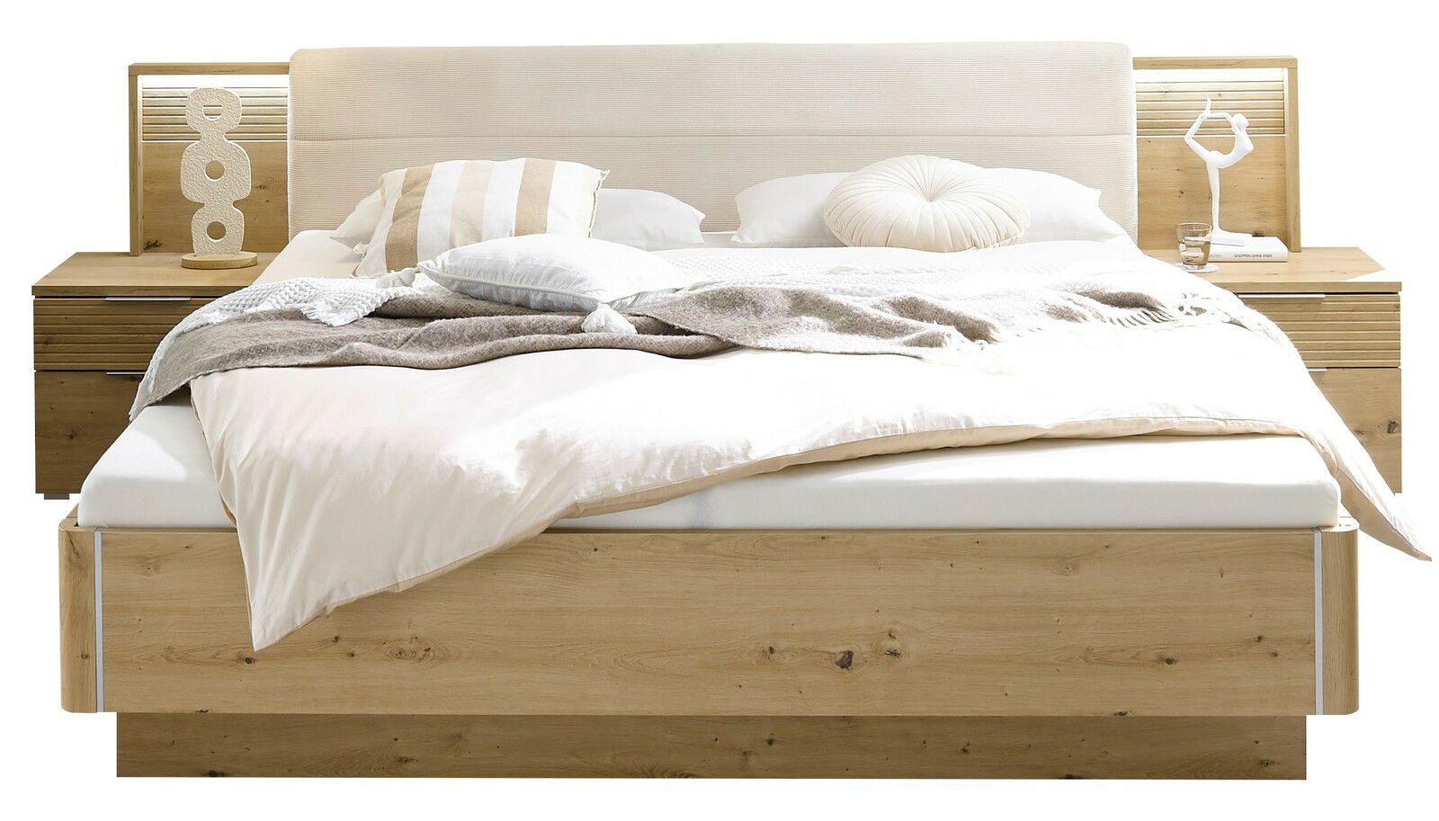 Frontale Ansicht einer modernen Bettanlage aus Holz mit integriertem Kopfteil und Nachttischen, dekoriert mit Kissen und Decken.