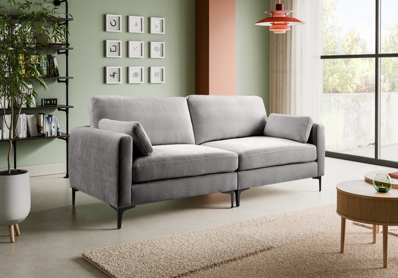 Modernes graues 2-Sitzer-Sofa mit Stoffbezug, schwarzen Metallfüßen und zwei Kissen im Wohnzimmer Perspektive: frontale Ansicht leicht von links.
