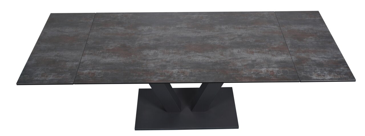 Moderner Esstisch mit dunkler, steinartiger Tischplatte und V-förmigem Fuß, Ansicht von oben.