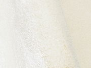 Nahaufnahme eines cremeweißen Uni-Teppichs mit weicher Textur, seitliche Perspektive