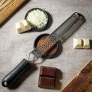 Feine und grobe Reibe von KÜCHENPROFI, von oben fotografiert, umgeben von geriebener Schokolade und Schokoladenstücken.