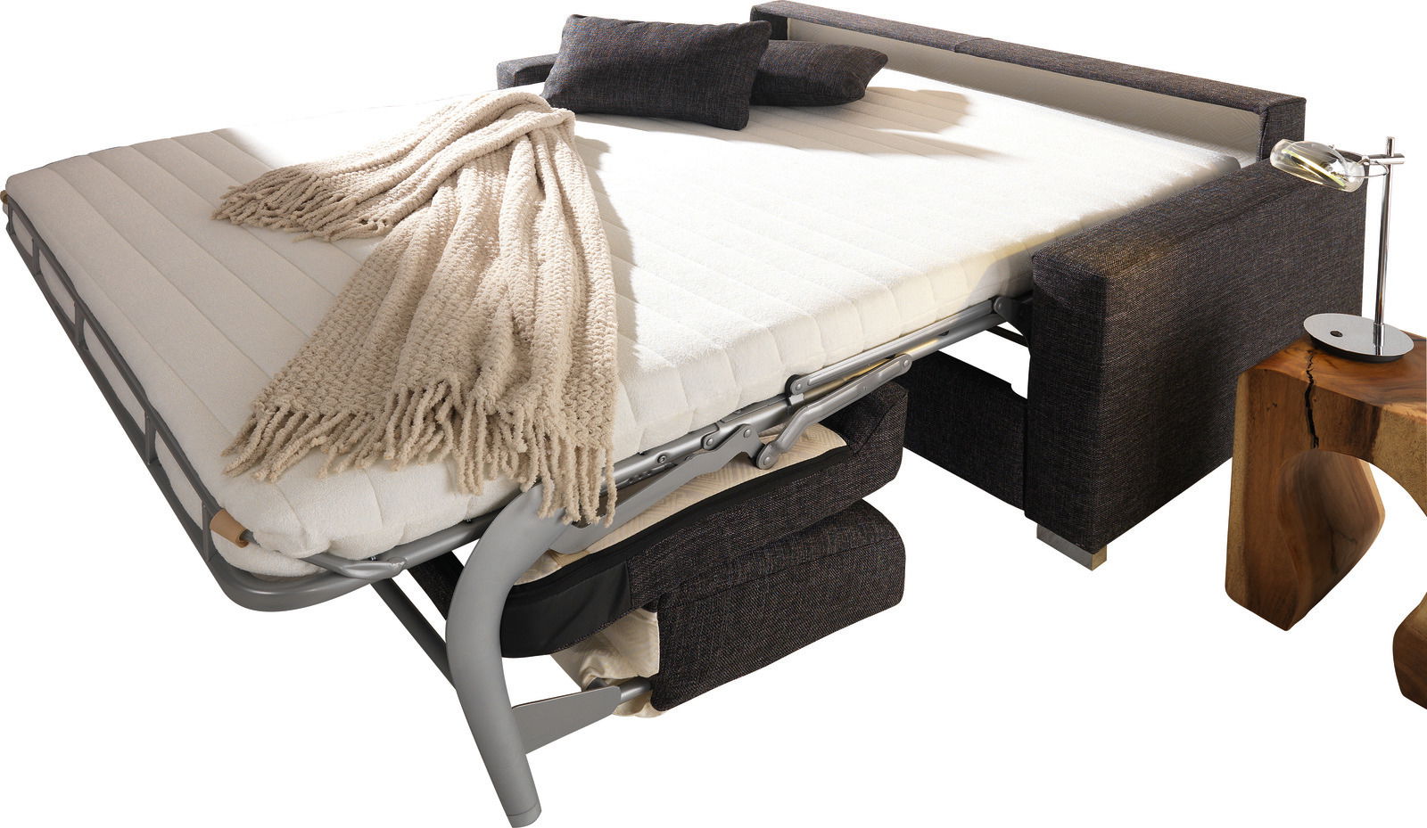 Verwandlungssofa in ausgeklappter Position mit beiger Decke und Kissen, seitliche Perspektive