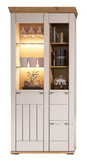 Frontansicht einer modernen Kombi-Vitrine mit Holz- und Glaselementen, beleuchtetem Innenraum, dekoriert mit Gläsern, Tassen und Büchern.