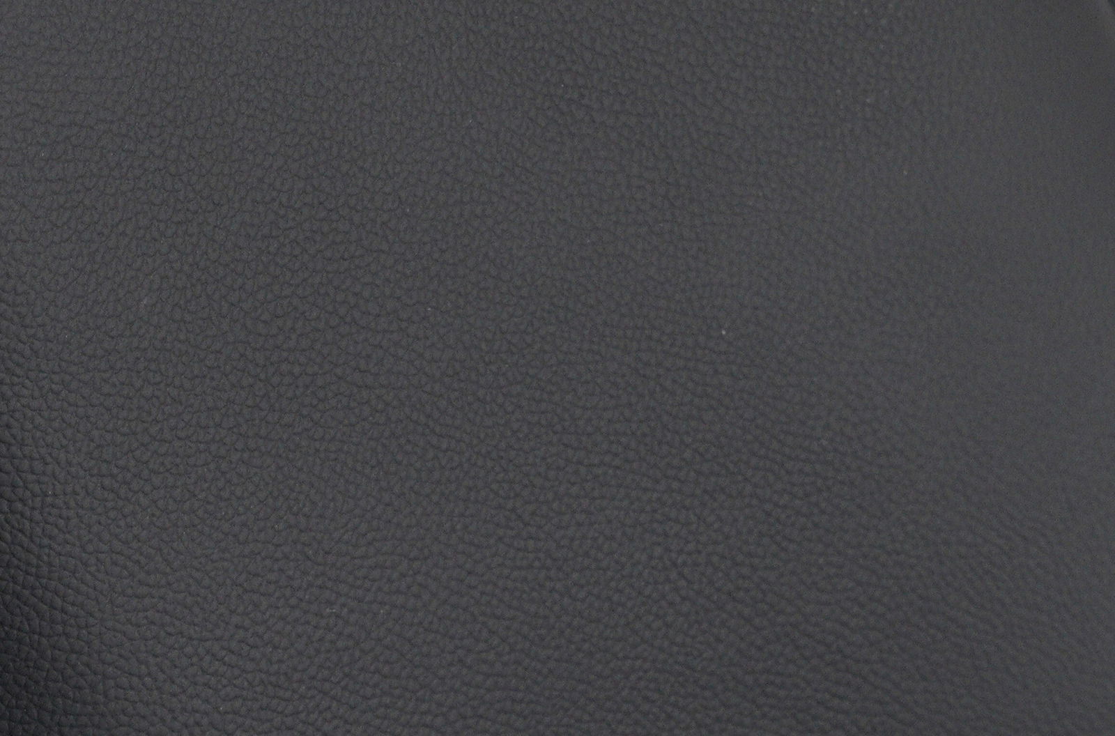 Nahaufnahme der schwarzen Lederstruktur eines Barhockersitzes