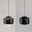 Moderne schwarze Pendelleuchte aus seitlicher Perspektive, mit elegantem, rundem Design und sanftem Lichtaustritt.