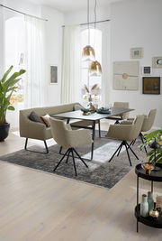 Esszimmer mit moderner Sitzgruppe, bestehend aus einem Tisch, einer Eckbank und mehreren Sesseln, aus seitlicher Perspektive fotografiert.