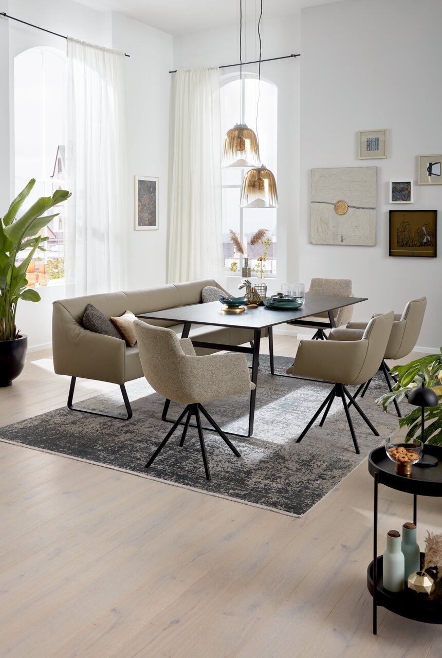 Musterring Stuhl MR JUSTB! SP500 Esszimmer mit moderner Sitzgruppe, bestehend aus einem Tisch, einer Eckbank und mehreren Sesseln, aus seitlicher Perspektive fotografiert.