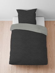 Bettwäsche-Set in Melange-Flanell, bestehend aus einem dunkelgrauen Bezug und einem hellgrauen Kissenbezug, auf einem Bett von oben fotografiert.