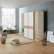 Moderner Dreh- und Schwebetürenschrank mit vier Türen in Holz- und Weißoptik, seitliche Perspektive im stilvollen Wohnzimmer.