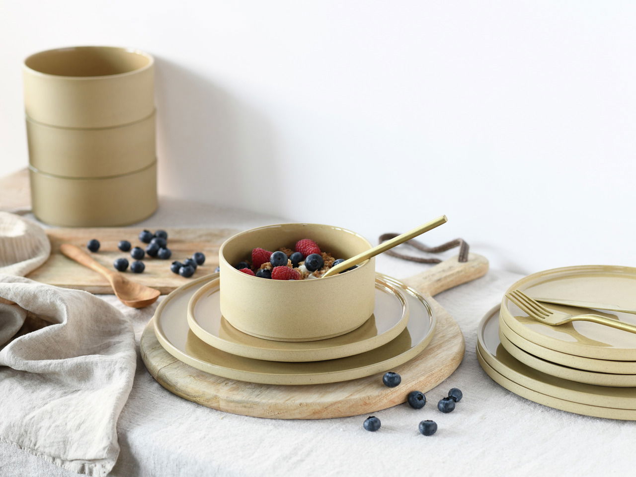 Tellerset Futuro Sand 12-tlg. in einer stilvollen Tischdekoration mit Beeren und Besteck, seitliche Perspektive