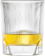 Nahaufnahme eines gerippten Whiskyglases mit goldenem Getränk, seitliche Perspektive