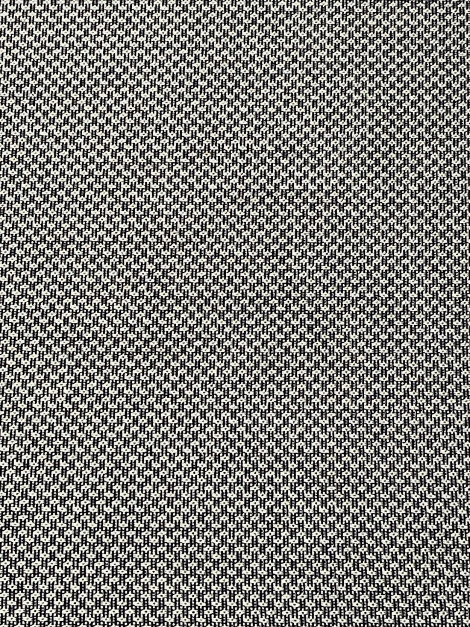 Nahaufnahme eines schwarz-weiß gemusterten Stoffes, der für eine Niederlehnerauflage verwendet wird.