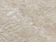 Nahaufnahme eines Designer-Teppichs mit beigem und cremefarbenem Muster, aus der Vogelperspektive fotografiert.