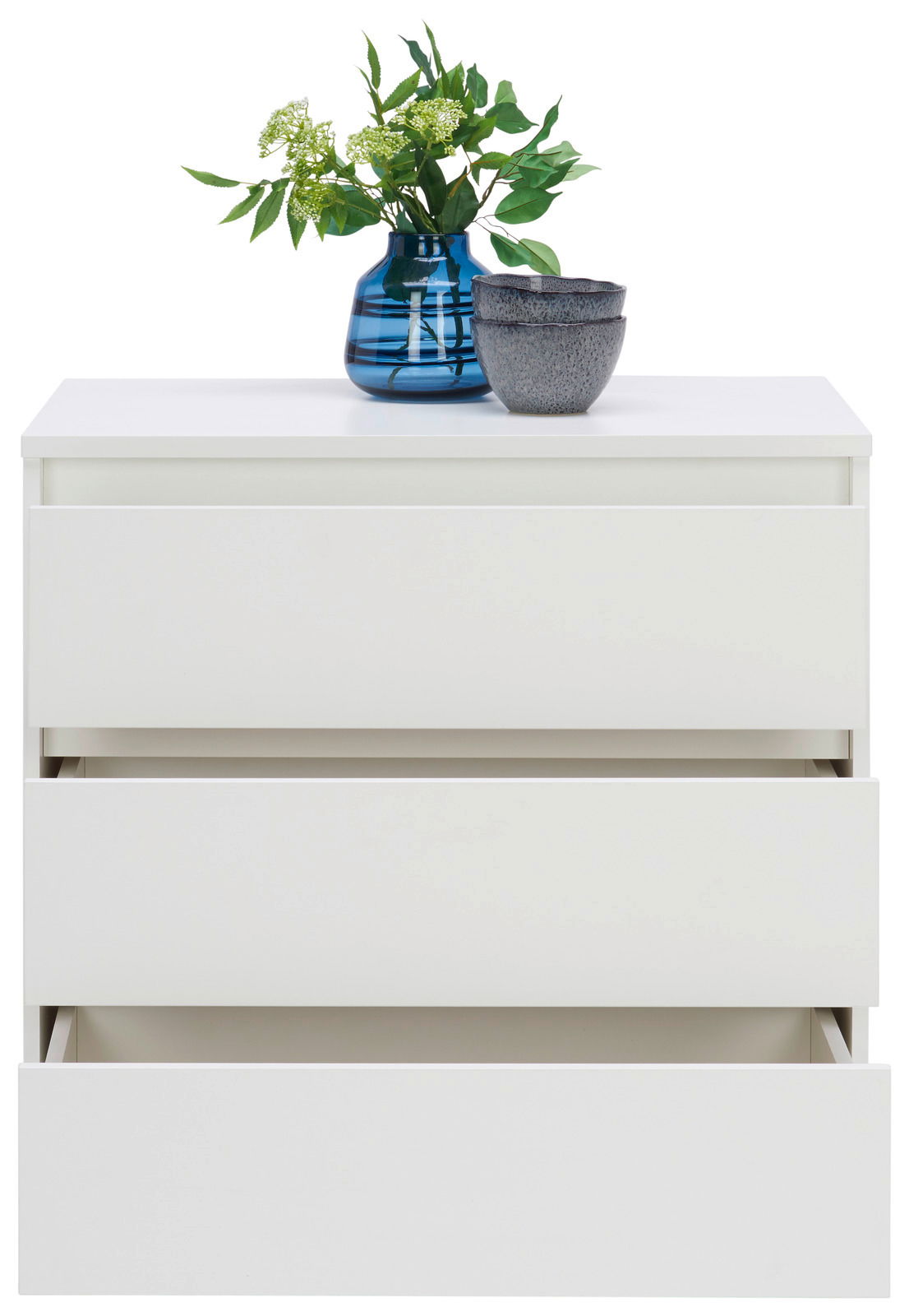 Weiße Kommode mit drei Schubladen, teilweise geöffnet, mit blauer Vase und grünen Pflanzen darauf, Frontalansicht
