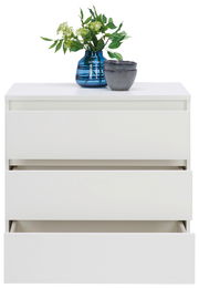 Weiße Kommode mit drei Schubladen, teilweise geöffnet, mit blauer Vase und grünen Pflanzen darauf, Frontalansicht