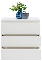 Weiße Kommode mit drei Schubladen, teilweise geöffnet, mit blauer Vase und grünen Pflanzen darauf, Frontalansicht