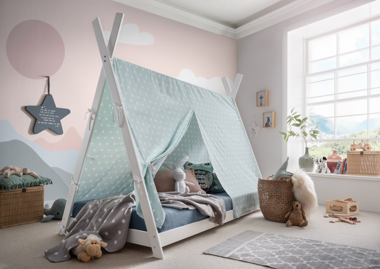 Zurbrüggen Stoffen dak PINOCCHIO Kinderkamer met een tentbed, bedekt met een lichtblauw stoffen dak met witte sterren. Zijaanzicht dat het tentbed en de gezellige inrichting van de kamer laat zien.