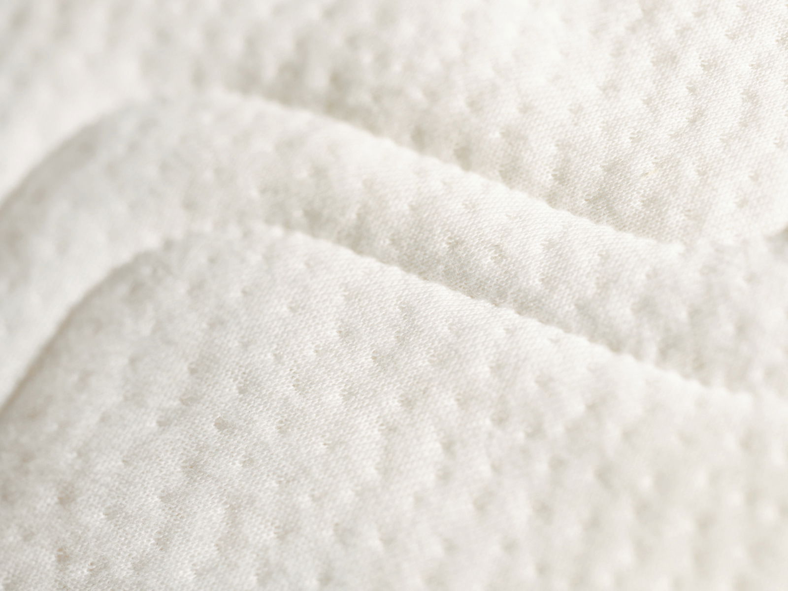 Nahaufnahme einer weißen Kaltschaummatratze mit strukturierter Oberfläche